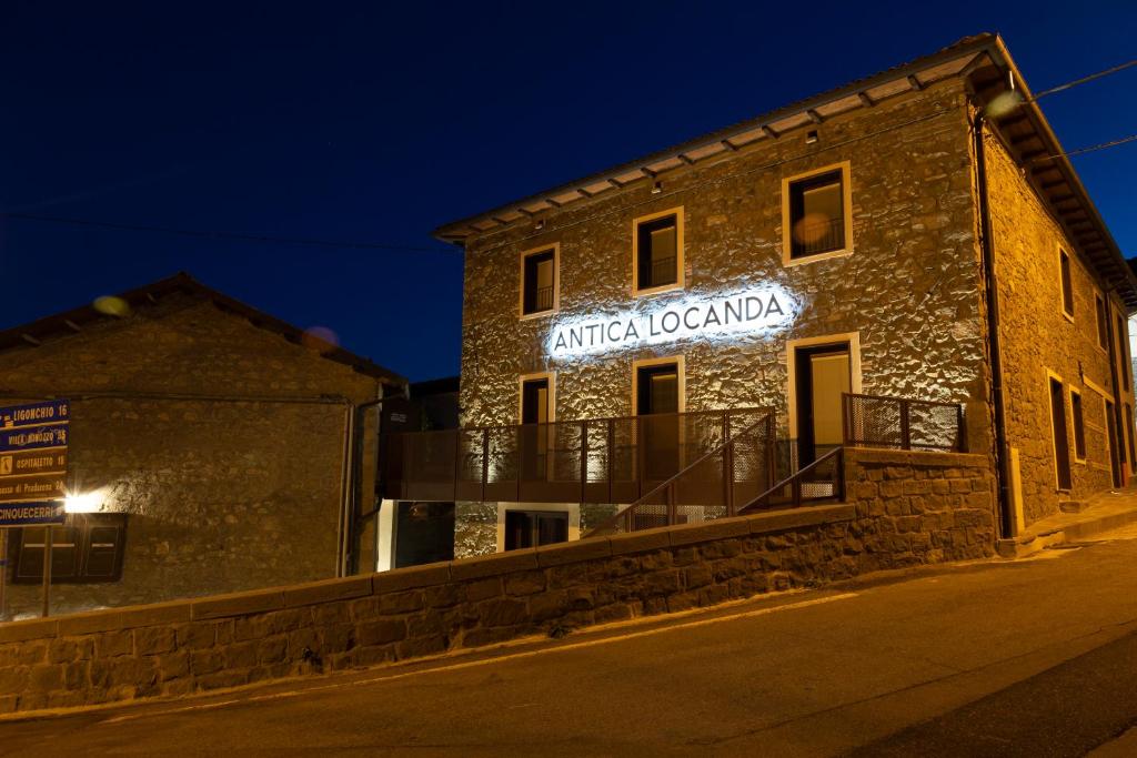 BusanaAntica Locanda Bonfiglio的一座建筑物,晚上在建筑物的一侧有标志