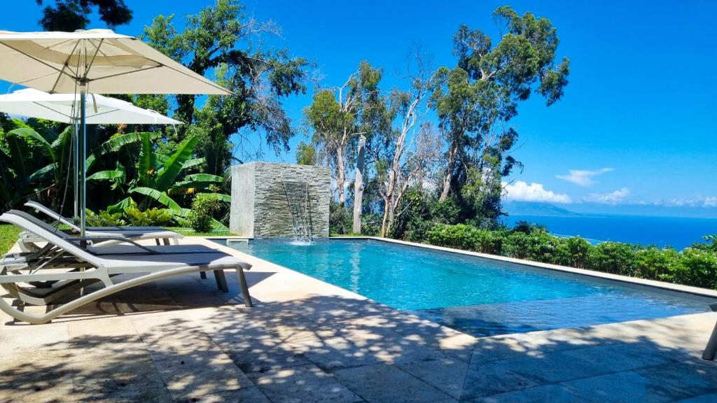 PiraeHorizon Hill Villa的一个带两把椅子和遮阳伞的游泳池