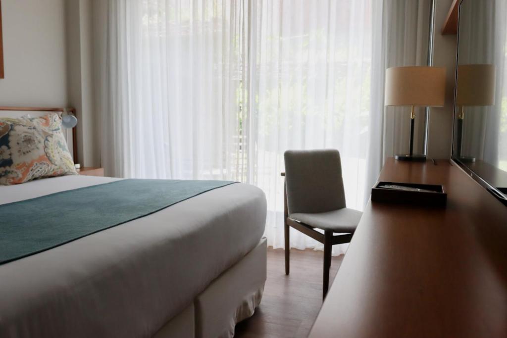 蒙得维的亚波托布西奥酒店的一间卧室配有一张床、一张桌子和一把椅子