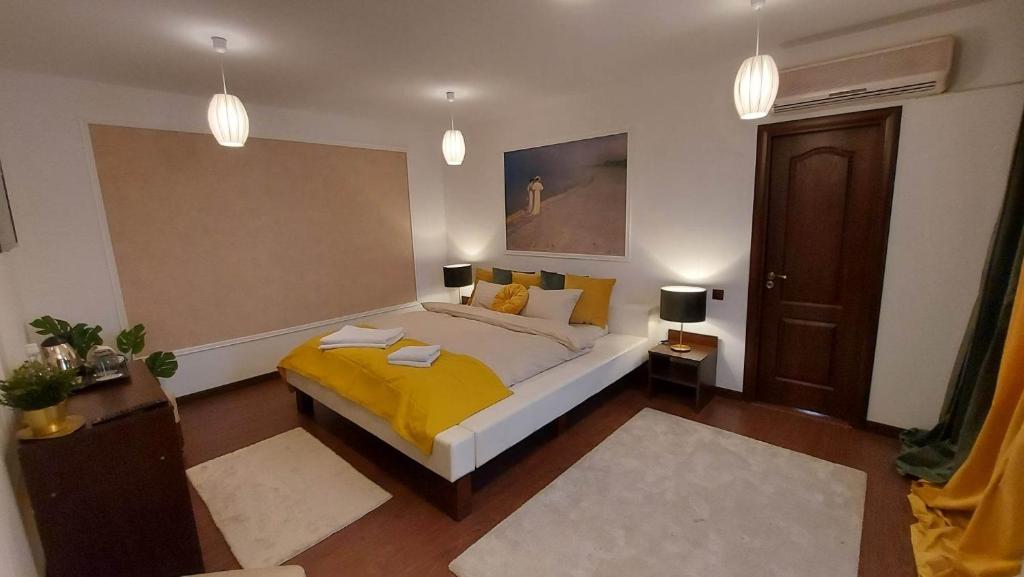 布加勒斯特Ambiennt的一间卧室配有一张黄色毯子床