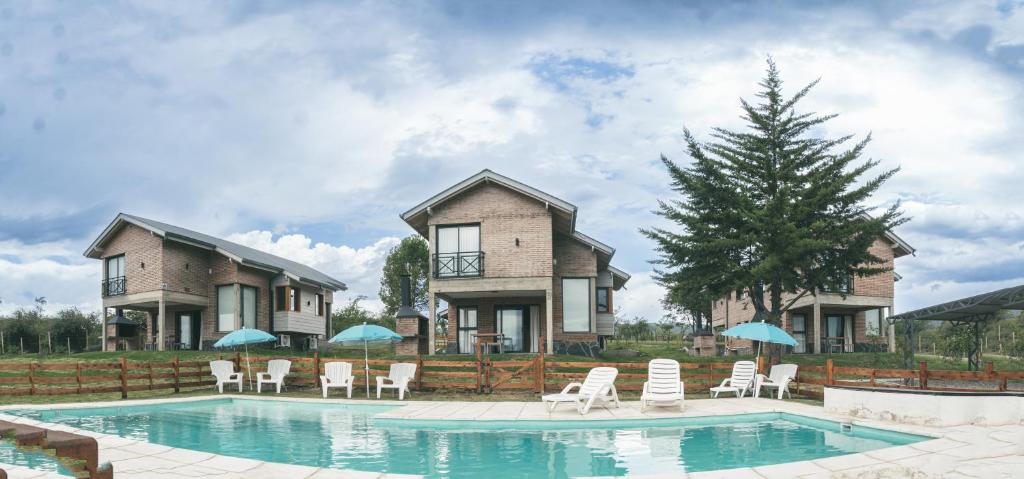 贝尔格拉诺将军镇Pentagrama, casas de campo的一座房子,设有一座带椅子和遮阳伞的游泳池