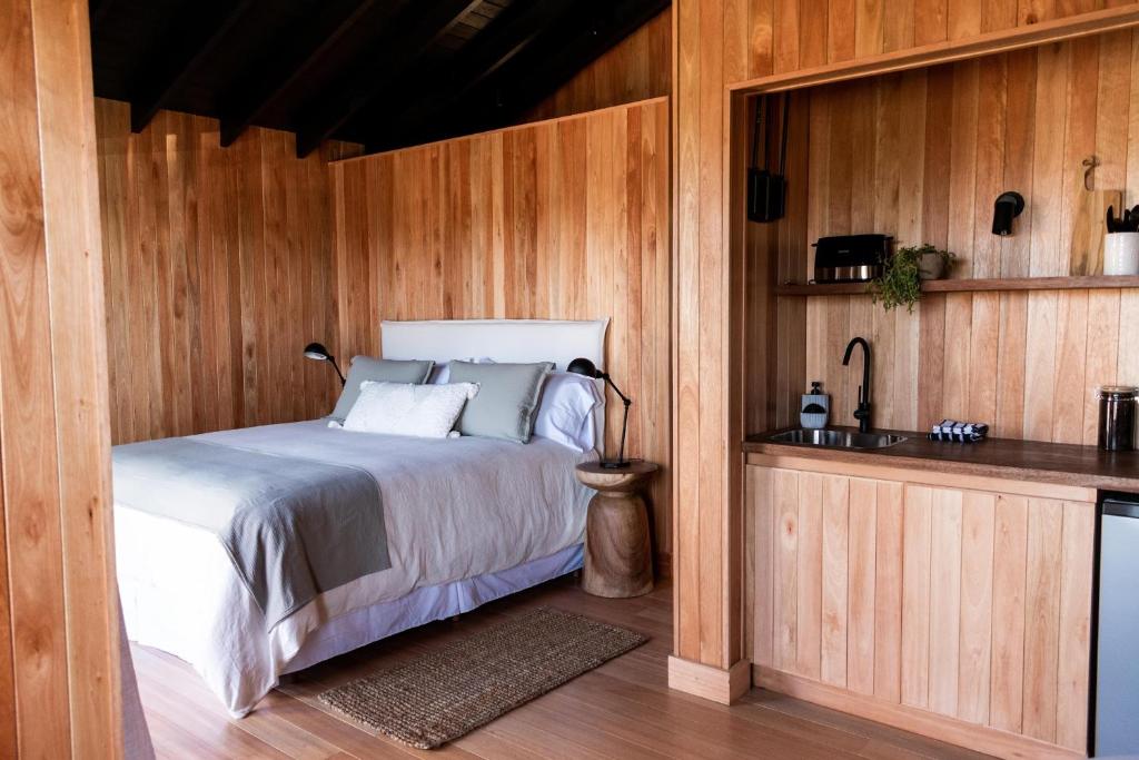 何塞伊格纳西奥Aires Puros的卧室配有木墙内的一张床