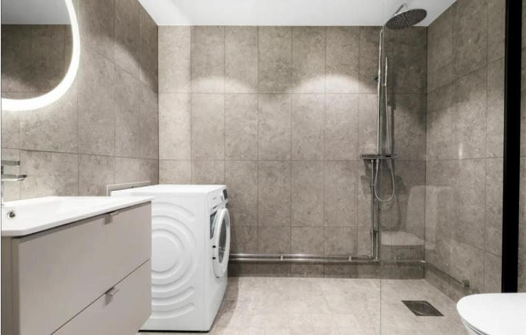斯德哥尔摩Solna Property Apartment的一间带洗衣机和淋浴的浴室