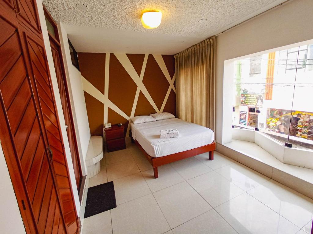齐克拉约Hotel Plaza Teatro的一间小卧室,配有床和窗户