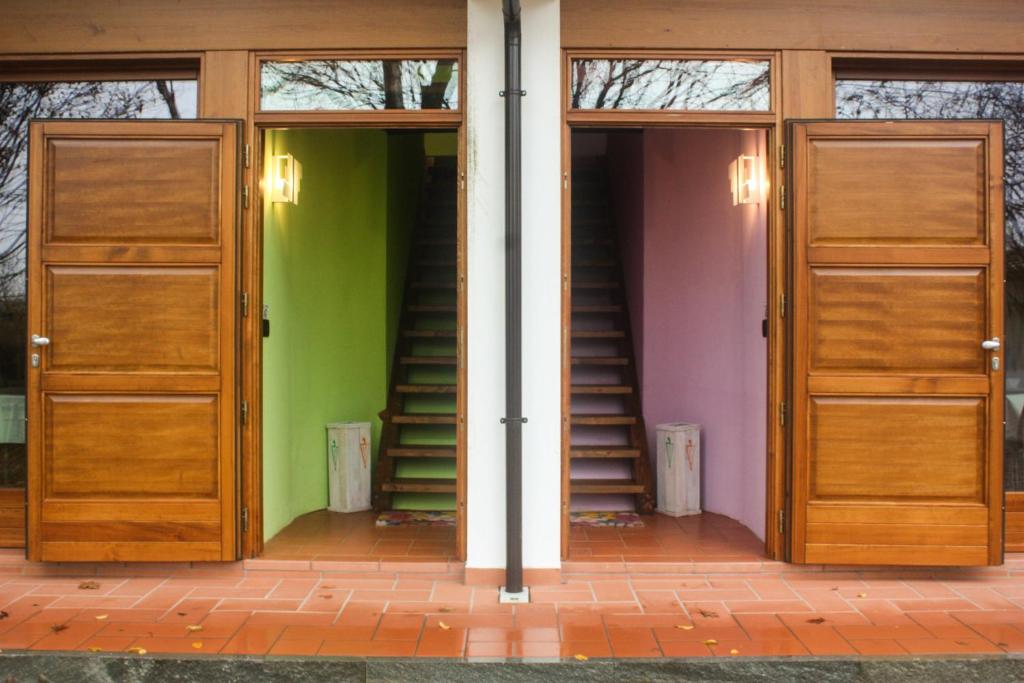 Bibiana伊尔弗鲁托佩美索农家乐的一间设有两扇木门和绿色墙壁的房间