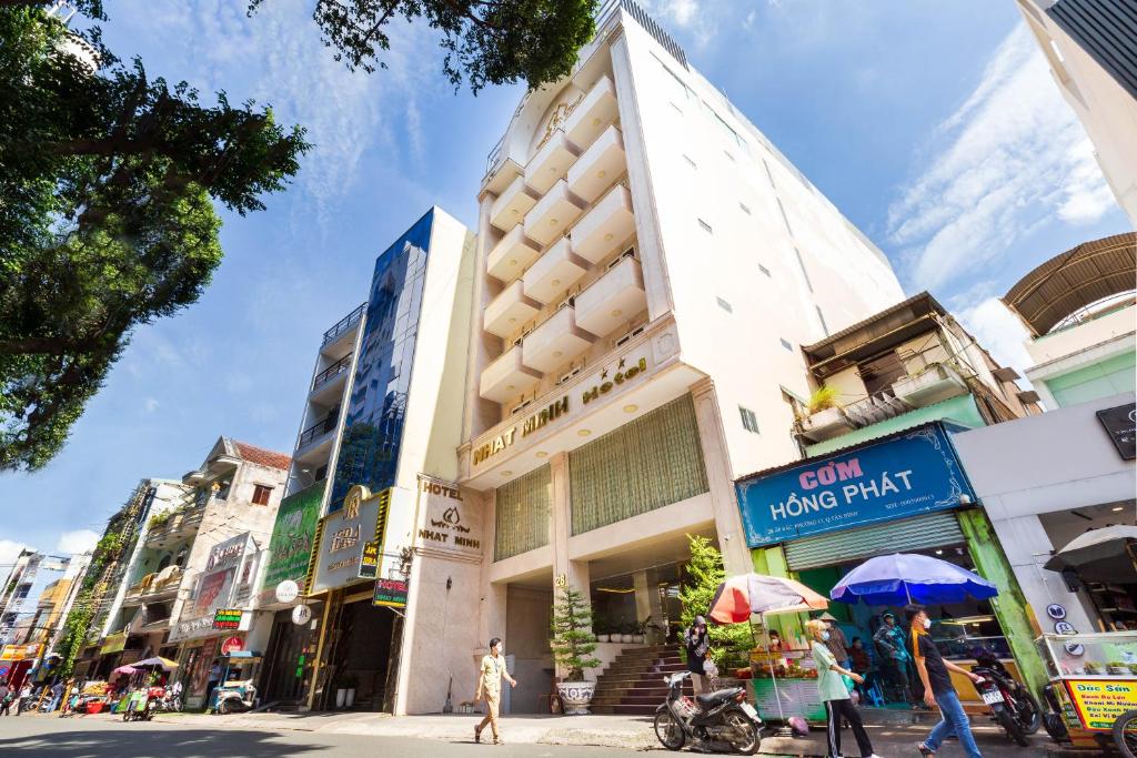 胡志明市Nhat Minh Hotel - Etown and airport的街上的一座建筑,街上的人在街上行走