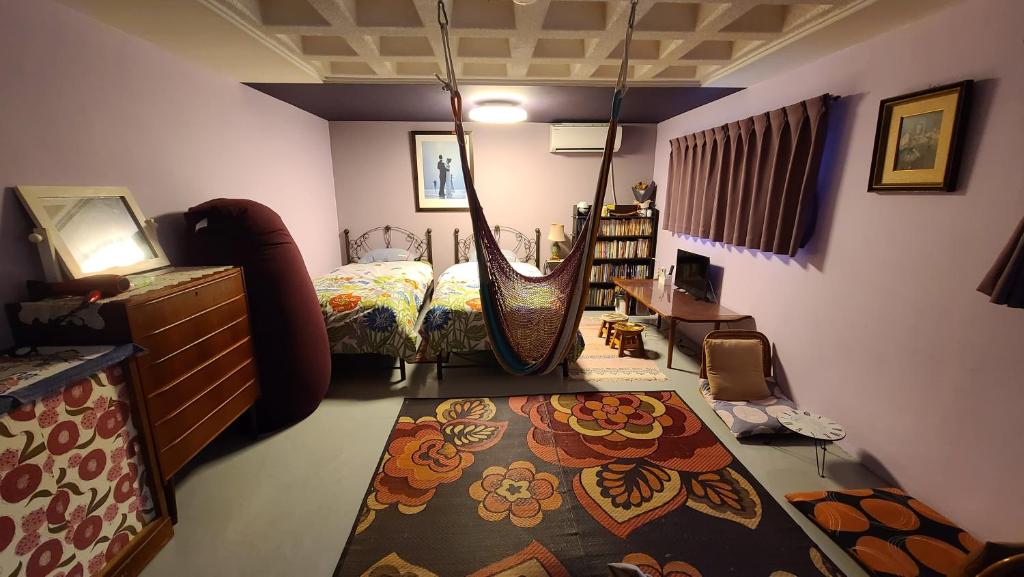 那霸Haruka 紫的一间卧室配有一张床和一个大型秋千
