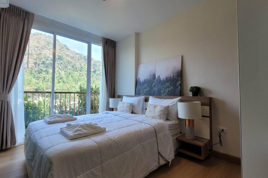 Ban Tha MaprangBaan Khaoyai cozy的一间卧室设有一张大床和一个大窗户