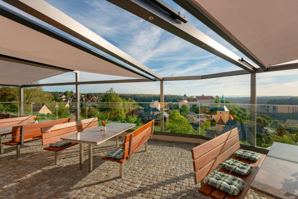 霍恩斯泰因Hotel Zur Aussicht的美景庭院设有桌子和长椅。