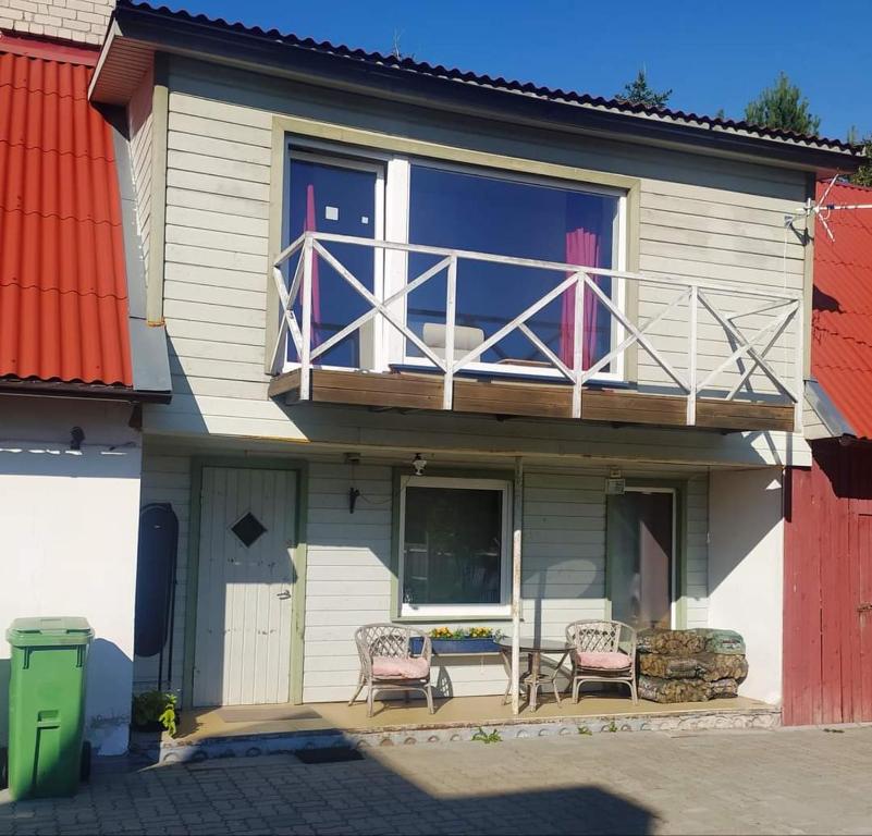 ValgmaSaadjärve Kingu talu puhkemaja的房屋设有阳台,配有两把椅子和一张桌子