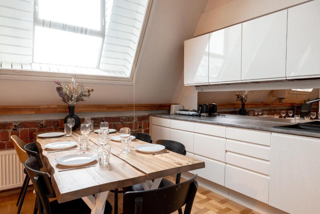 赫尔辛基2ndhomes Luminous & Modern 107m2 Penthouse in Kruununhaka的一间带木桌和椅子的厨房以及一间用餐室