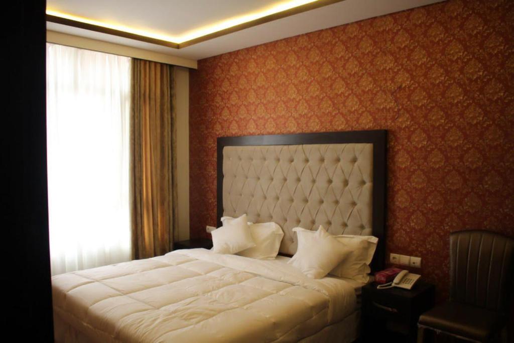 赫拉特Sadaf Hotel in Herat的卧室配有一张大白色床和窗户