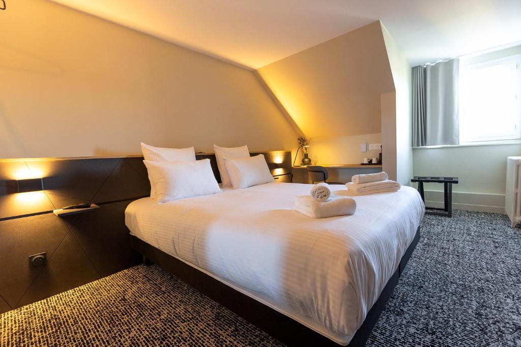 弗兰奎维尔-圣皮尔Logis Hôtel & Restaurant Le Vert Bocage的卧室配有带毛巾的大型白色床