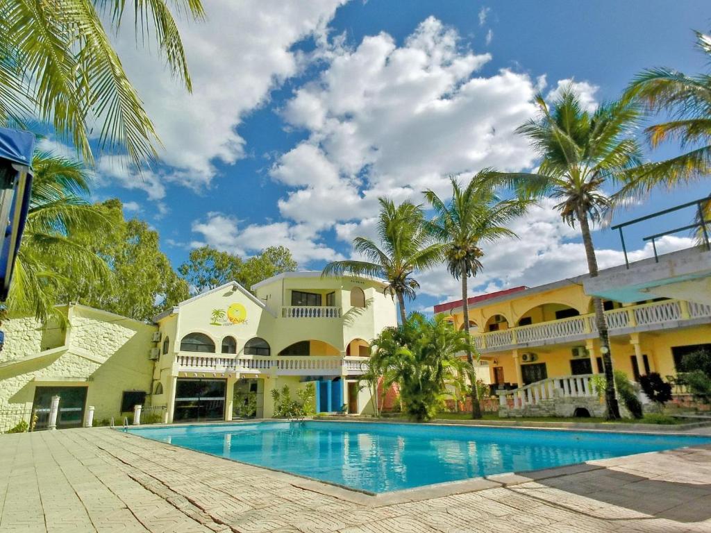 马哈赞加New Park Resort的棕榈树建筑前的游泳池