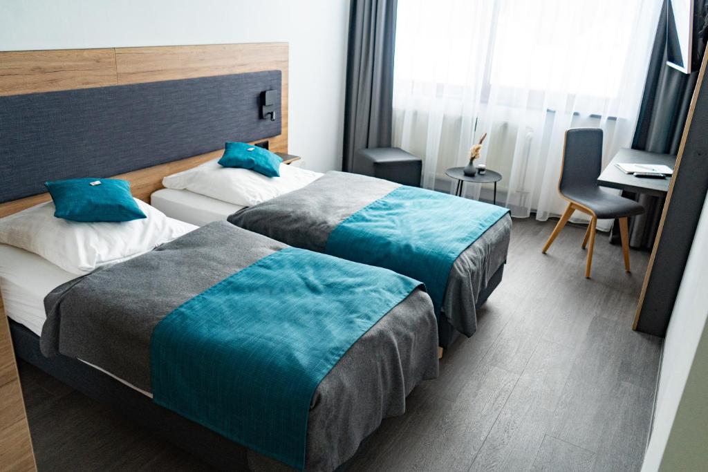 赖兴巴伊姆福格特兰埃姆帕克酒店的酒店客房配有两张床和一张书桌