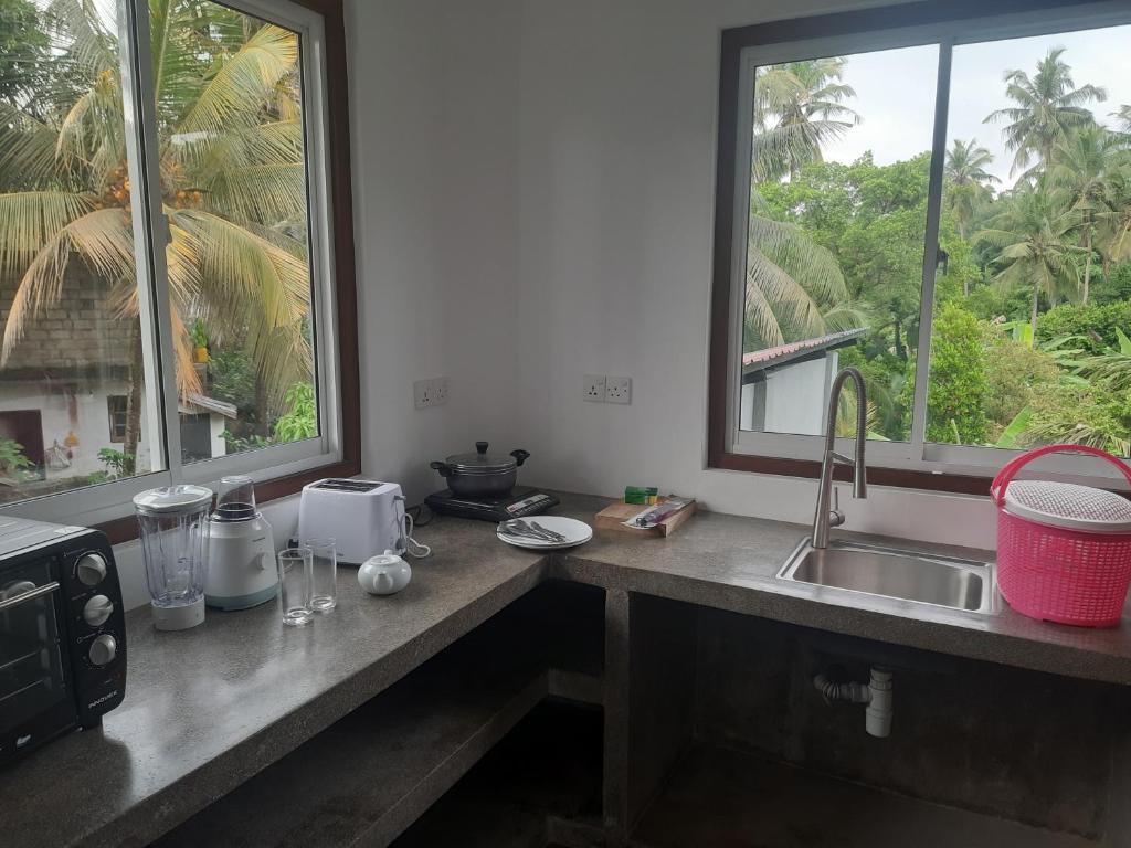 乌纳瓦图纳Hotel Paradiso,的带水槽的厨房台面和2扇窗户