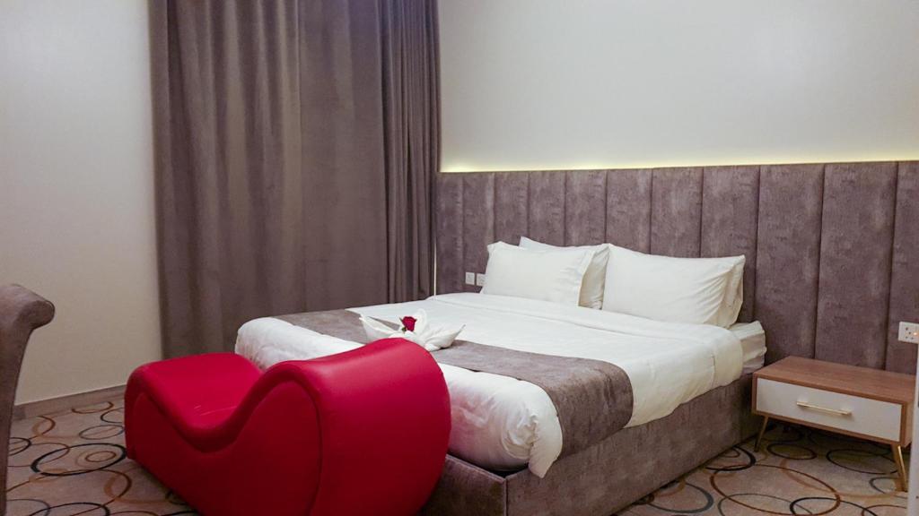艾卜哈جولدن أبها المضياف的一间卧室配有一张大床和一张红色椅子