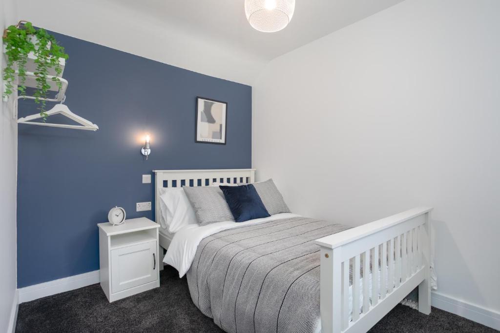 贝尔法斯特Central Avenue Apartment的卧室配有白色的床和蓝色的墙壁