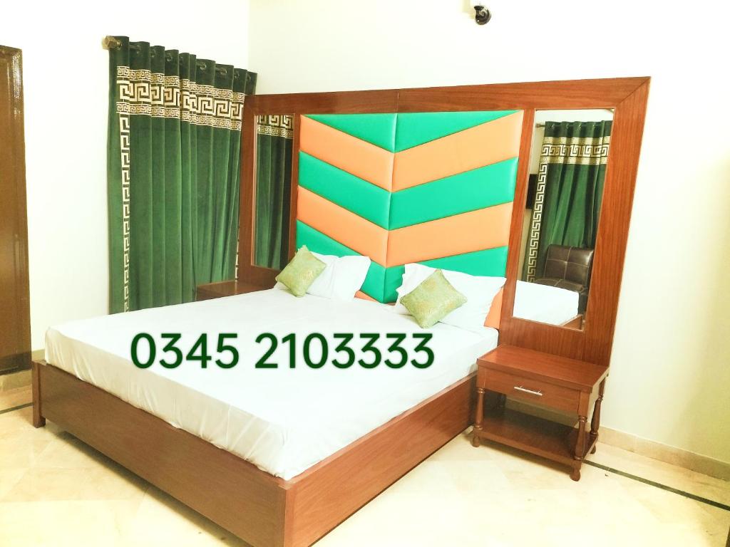卡拉奇Subhan Palace Guest House的一间卧室配有一张木架床和镜子