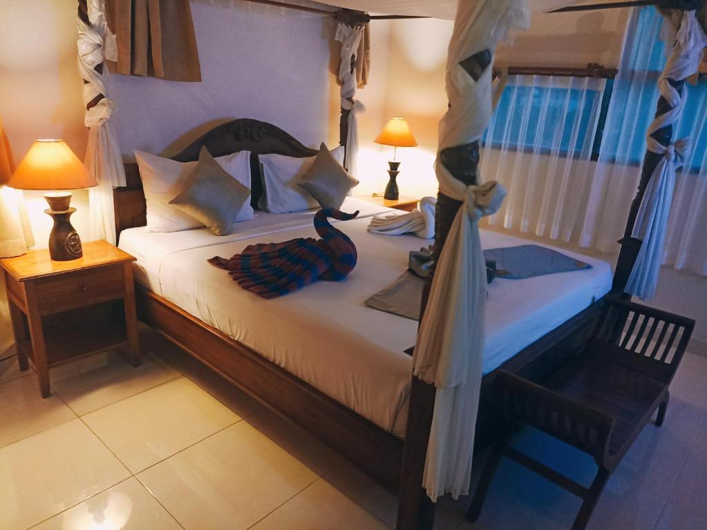 勒吉安库斯纳迪酒店的一间卧室配有一张床、一把椅子和两盏灯。