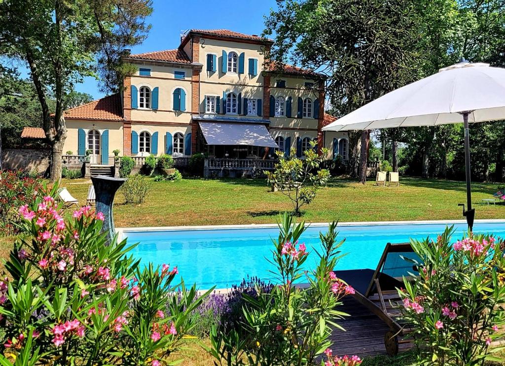 AlmayracOh, le château!的一座带游泳池和遮阳伞的大房子