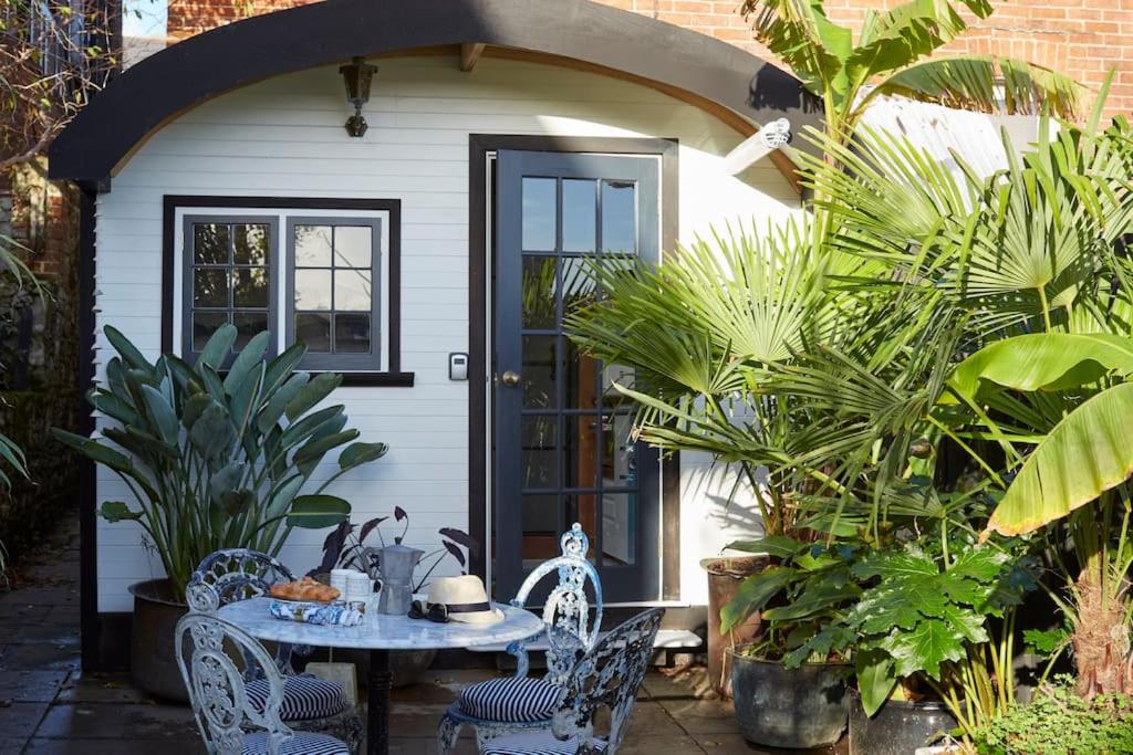 赖德The Cabana - a romantic seaside getaway and garden的门前带桌椅的房子