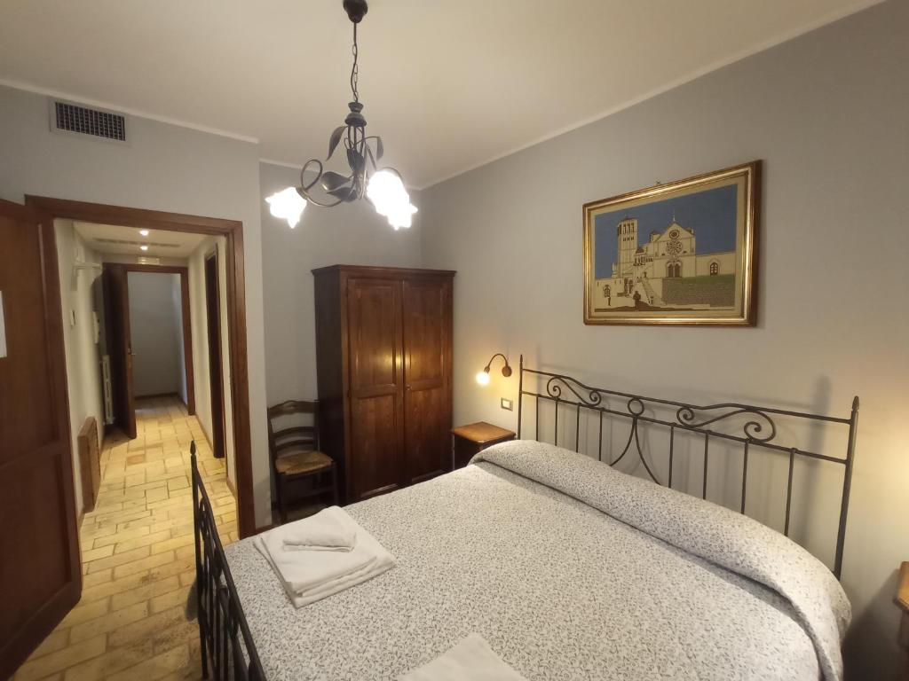 阿西西All'Ombra di San Damiano的卧室配有一张床,墙上挂着一幅画