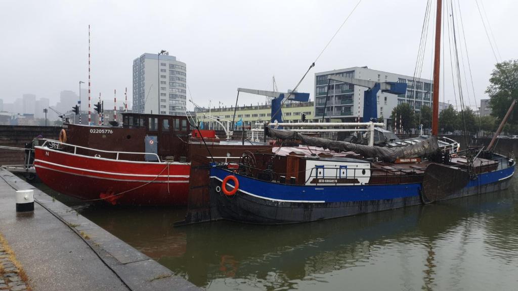 鹿特丹Boat-Apartment Rotterdam Fokkelina的两艘船在水中彼此对接