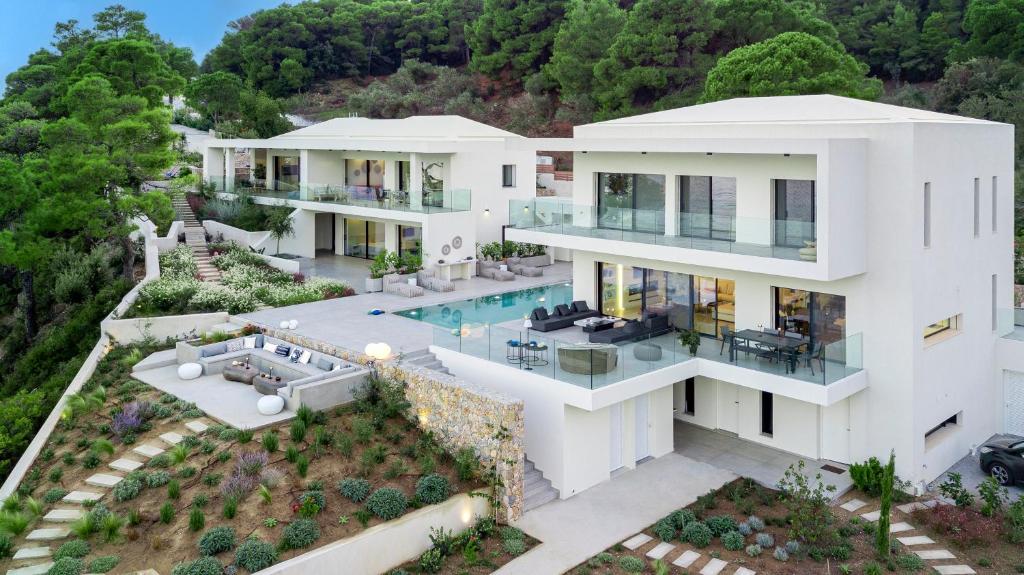 斯基亚索斯镇Luxury Villas Skiathos的享有白色房屋空中美景,设有游泳池
