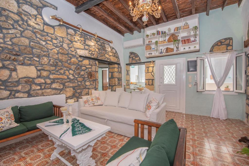 帕斯蒂达Philoxenia traditional house的带沙发和石墙的客厅