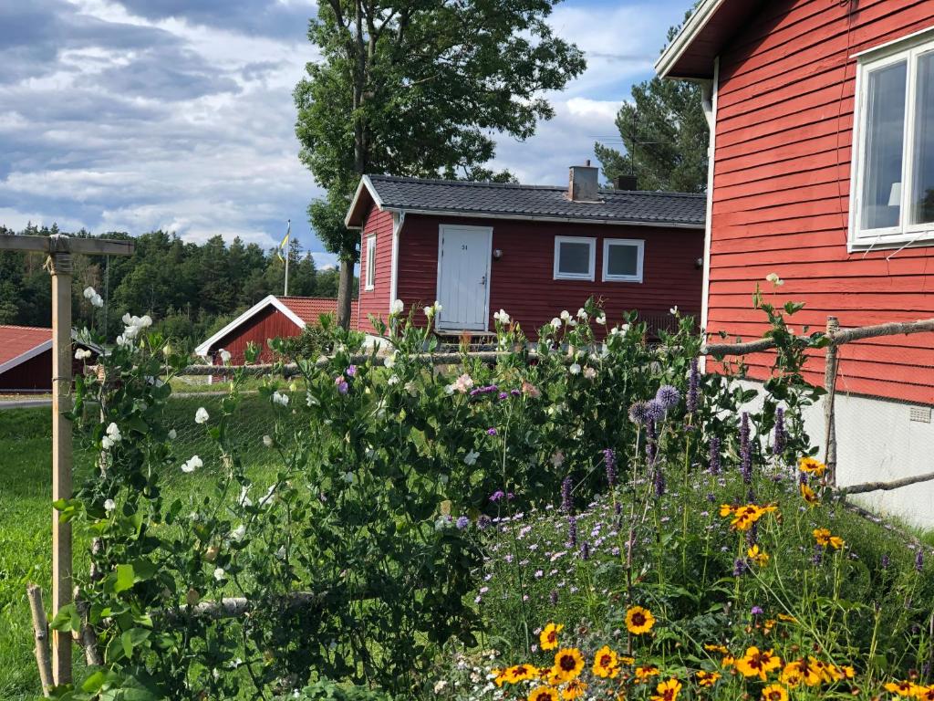 格兰纳Vättersmålen Stuga的鲜花盛开的红色房子前面的花园