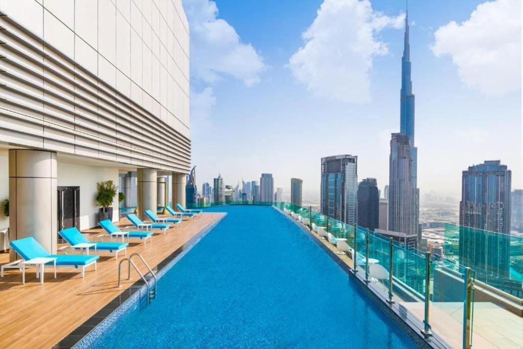 迪拜Paramount Hotel Midtown Flat with Burj Khalifa View的一座城市天际线建筑屋顶上的游泳池
