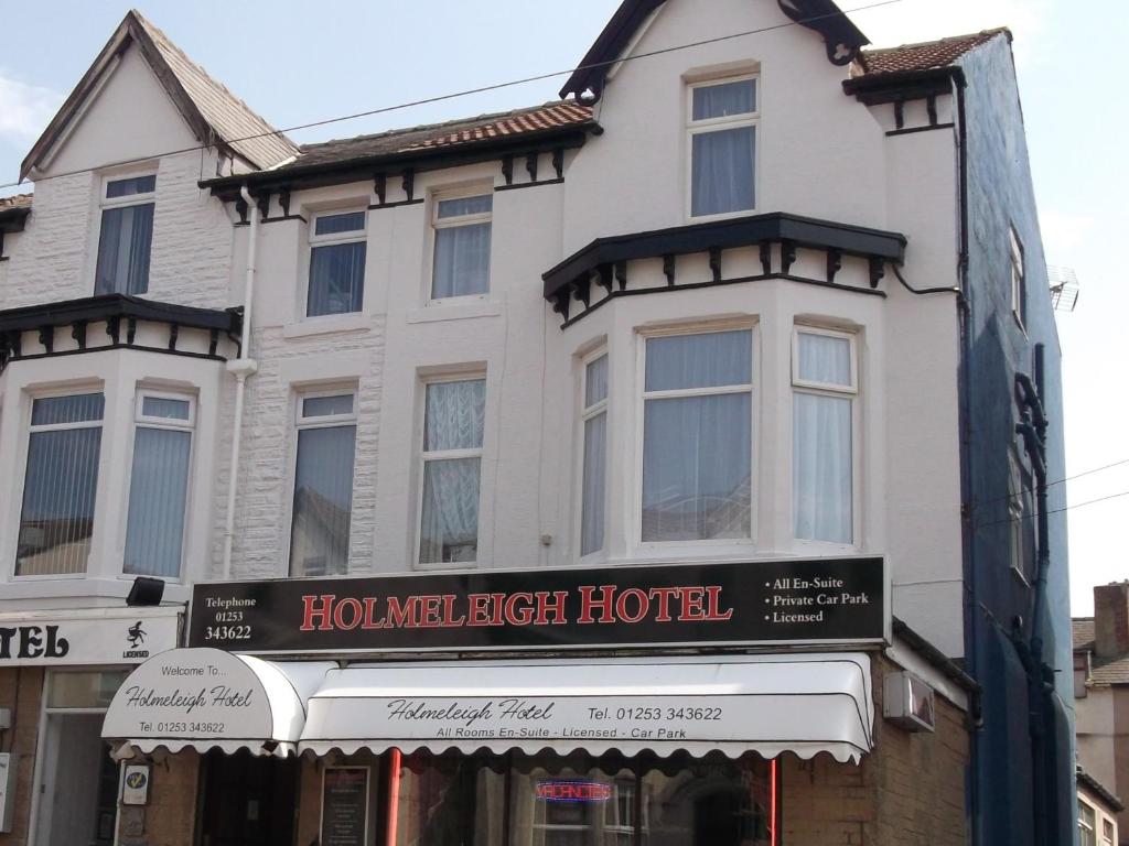 布莱克浦Holmeleigh Hotel的一座白色的大建筑,标有酒店标志