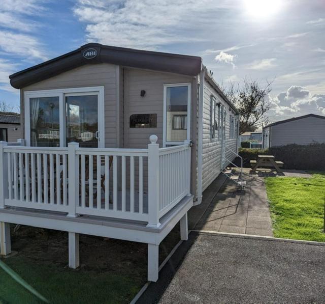 韦茅斯PEACEFUL HOMELY Caravan IN LOVELY CUL DE SAC Littlesea Haven Weymouth的一间白色栏杆和门廊的小房子