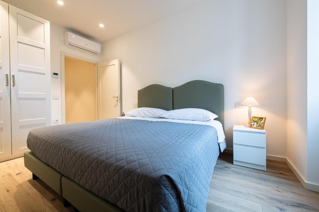 佩尔吉内瓦尔苏加纳帕拉佐琪麦丽公寓的一间卧室配有一张带蓝色棉被和床头柜的床