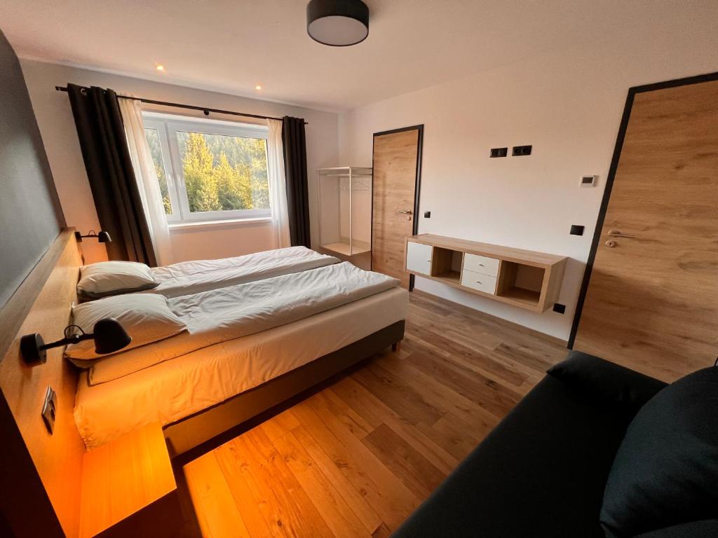珀尔蒂尼什NORDIC Apartamente Păltiniș的一间卧室设有一张床和一个窗口