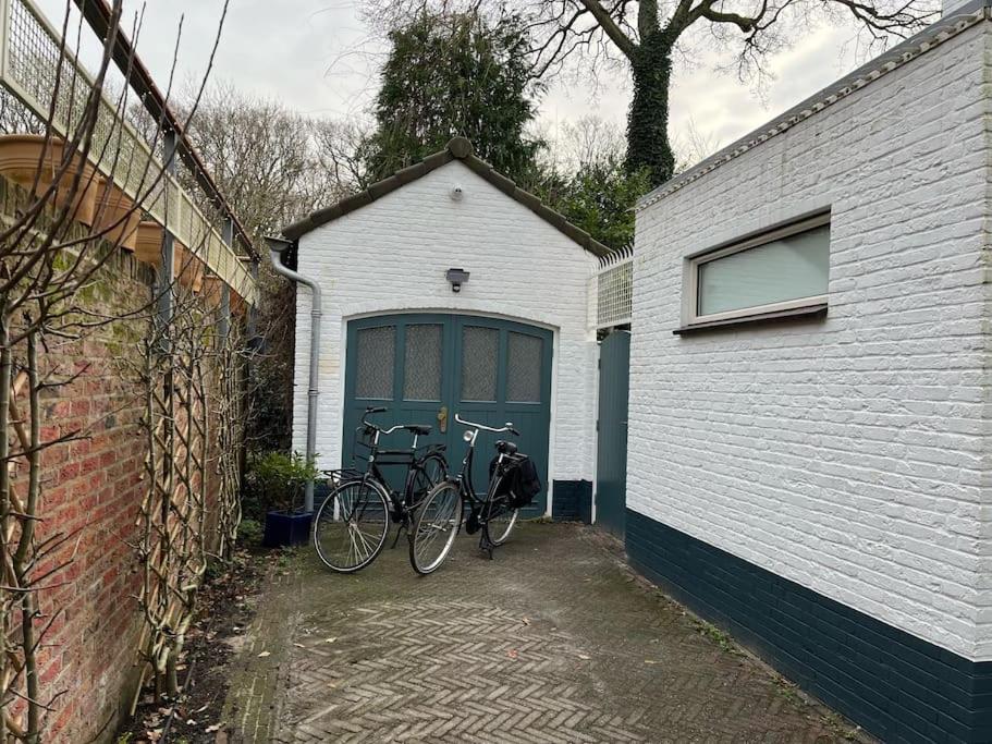 海牙Renovated & private Tinyhouse Den Haag short stay appartment的停放在车库前的几辆自行车