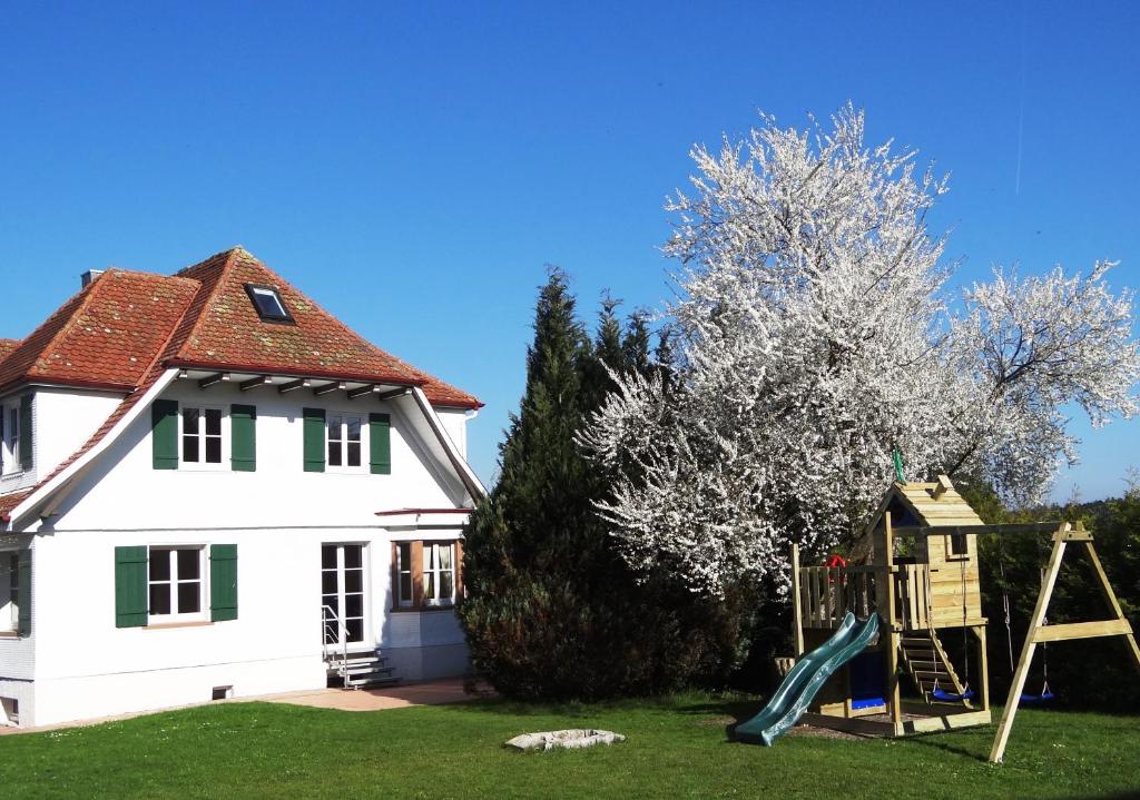 Gemeinde AichhaldenSchwarzwaldhaus24 - Ferienhaus mit Sauna, Whirlpool und Kamin的房屋前带游乐场的房子