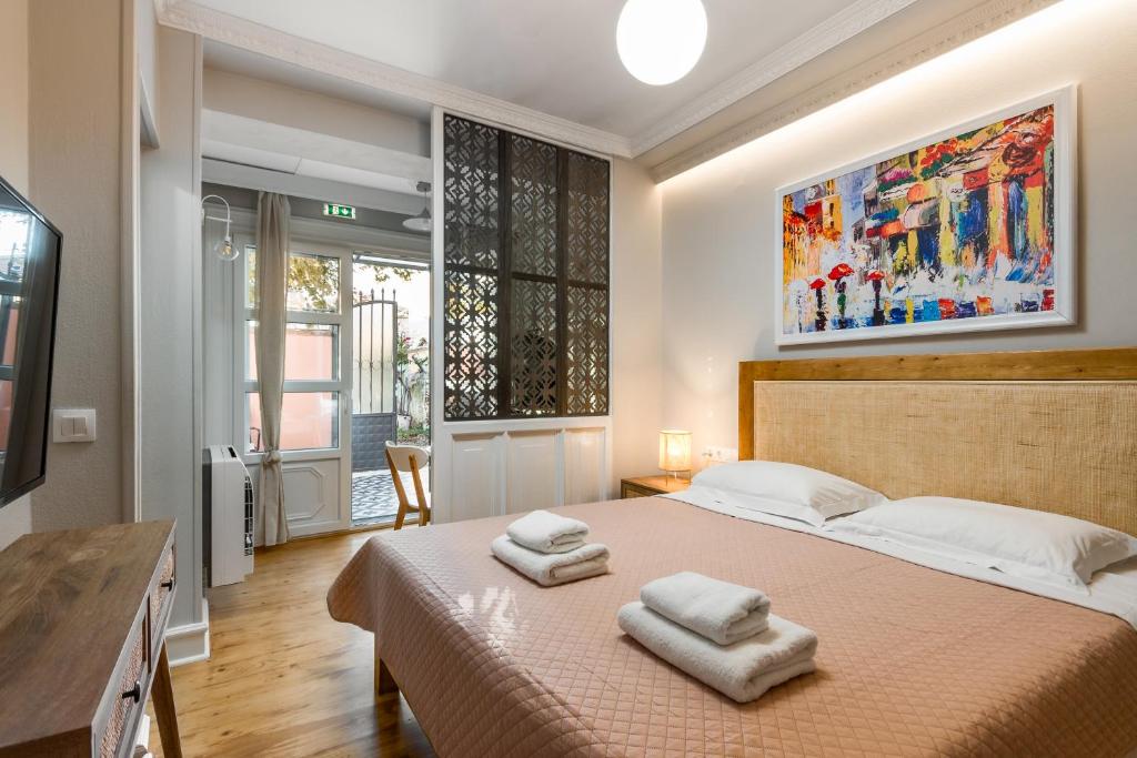 AnemómylosWell Apartments by Skyloft Corfu的一间卧室配有一张床,上面有两条毛巾
