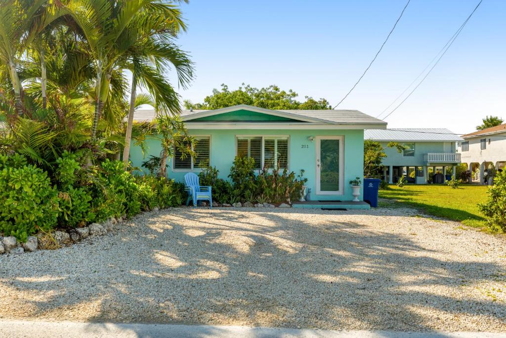 基克罗尼海滩KCB Bungalow的棕榈树蓝色房子