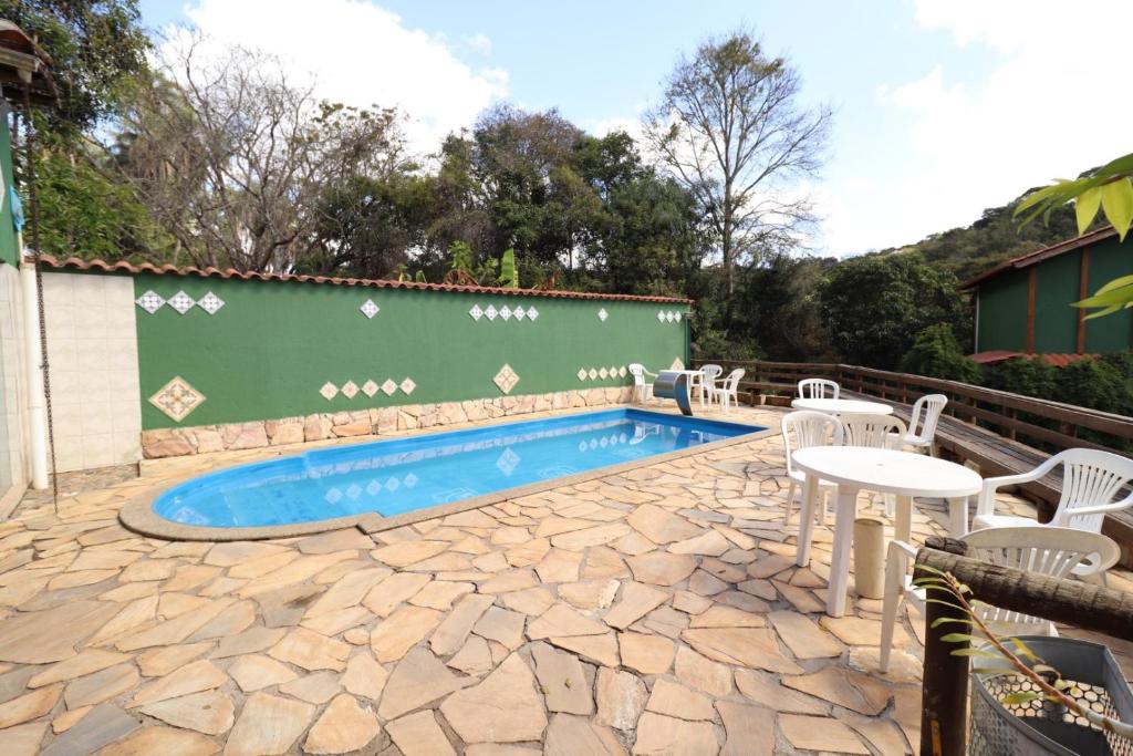 马卡科斯玛丽亚波尼塔宾馆的庭院设有游泳池、椅子和桌子。
