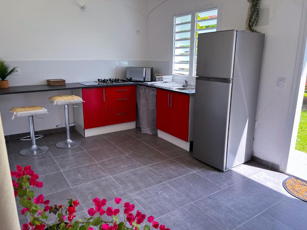拜马欧T2 Paisible et spacieux的厨房配有红色橱柜和不锈钢冰箱