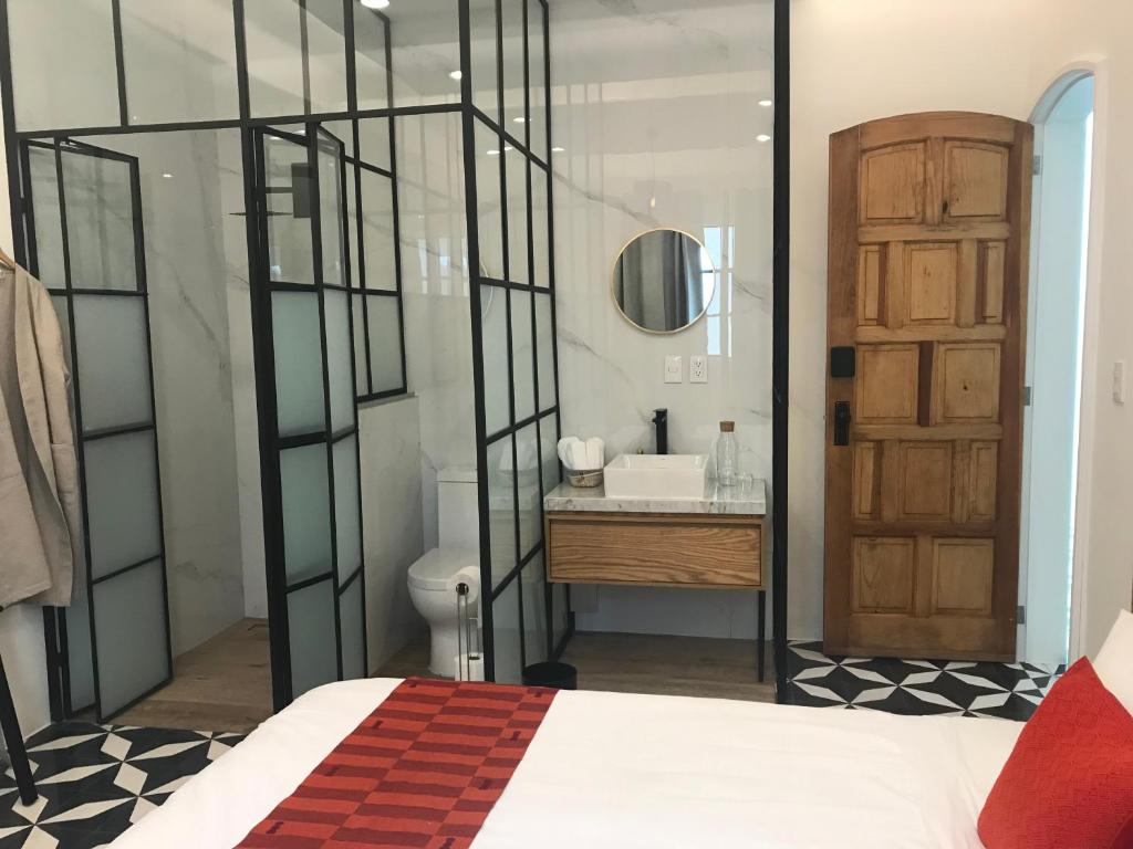 墨西哥城CASA LALIQUE的浴室设有床、水槽和镜子
