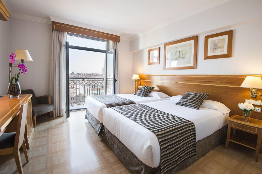 马德里VP都市花园酒店的配有大窗户的酒店客房内的两张床