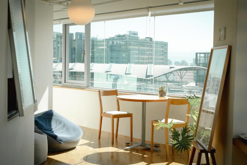 台中市路得行旅国际青年旅馆台中站前馆的客房设有桌椅和大窗户。