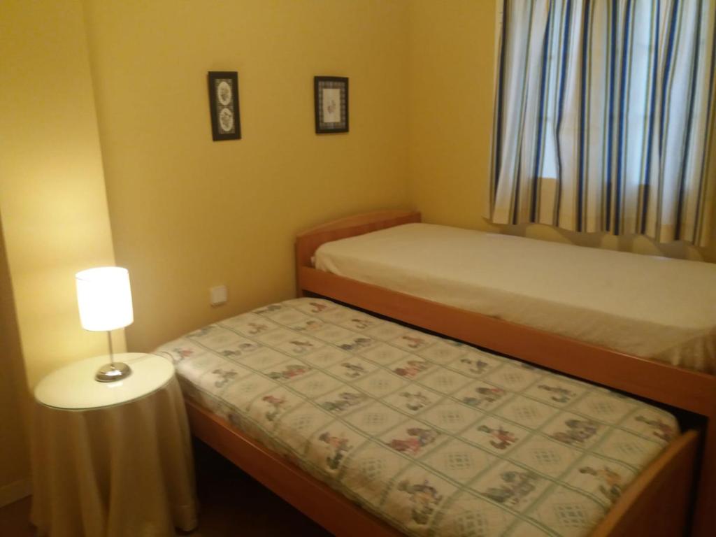 加的斯La Casita de Marina Golf-Costa Ballena的一间小卧室,配有两张床和一盏灯