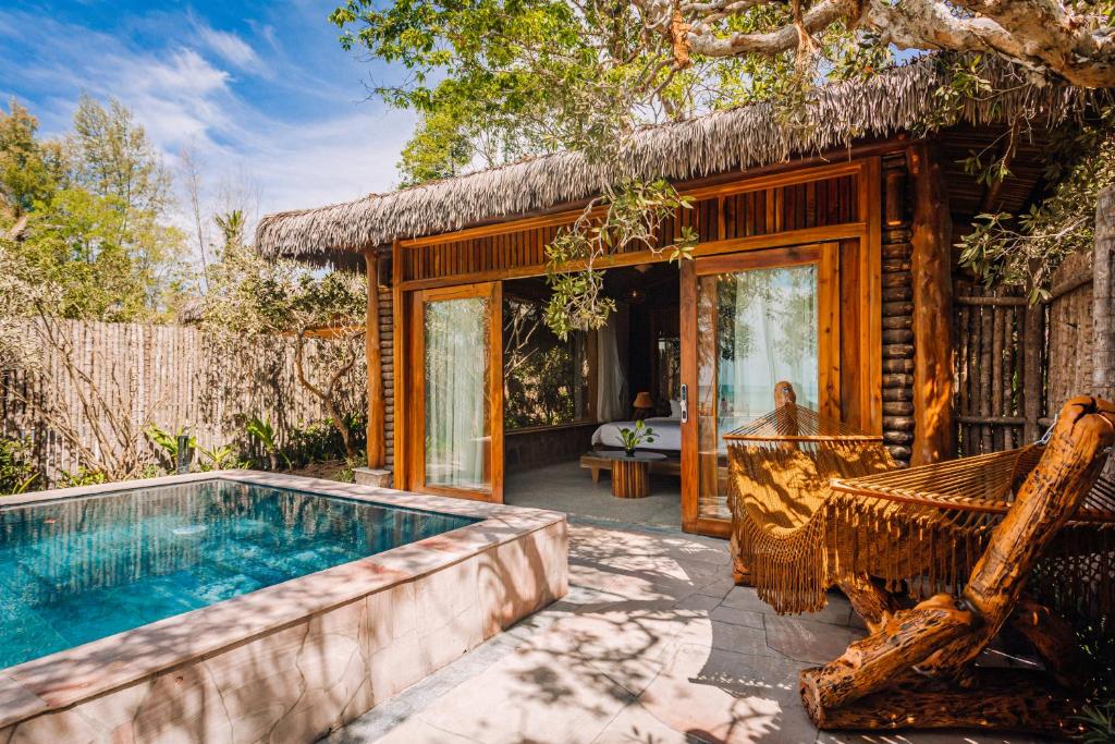 富国Ocean Bay Phu Quoc Resort and Spa的一个带游泳池和房子的度假胜地
