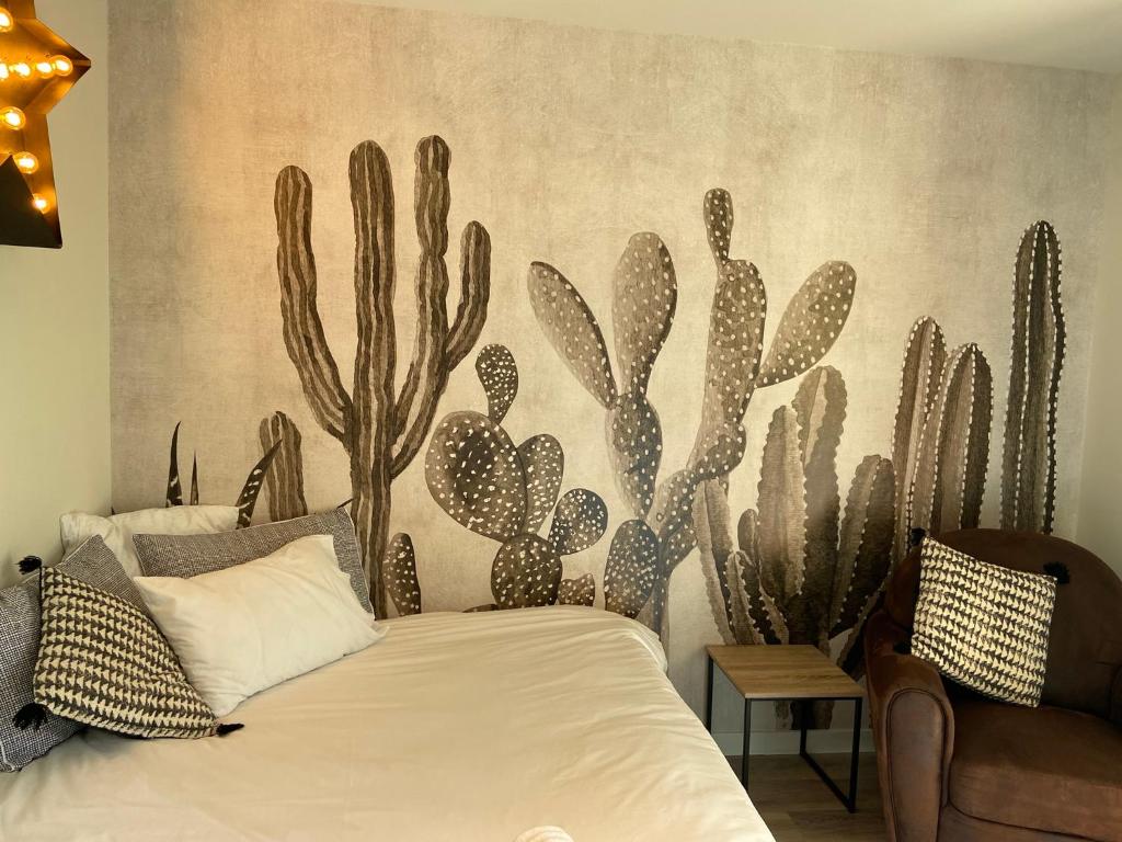 索恩河畔沙隆Le Nid Bourguignon的卧室配有一张壁挂着仙人掌壁画的床