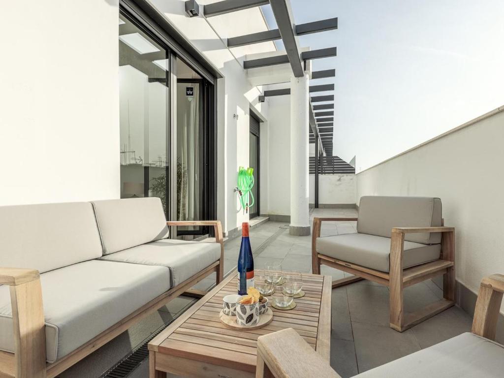 塞维利亚Uxama Sevilla Luxury Penthouse en Triana - Terraza y parking privados - piscina的客厅配有沙发和桌子