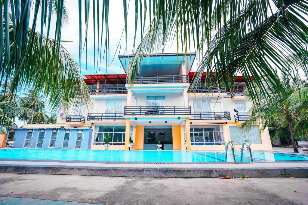 卡尔库达Sun Ray Rest House的建筑前的一座带游泳池的建筑